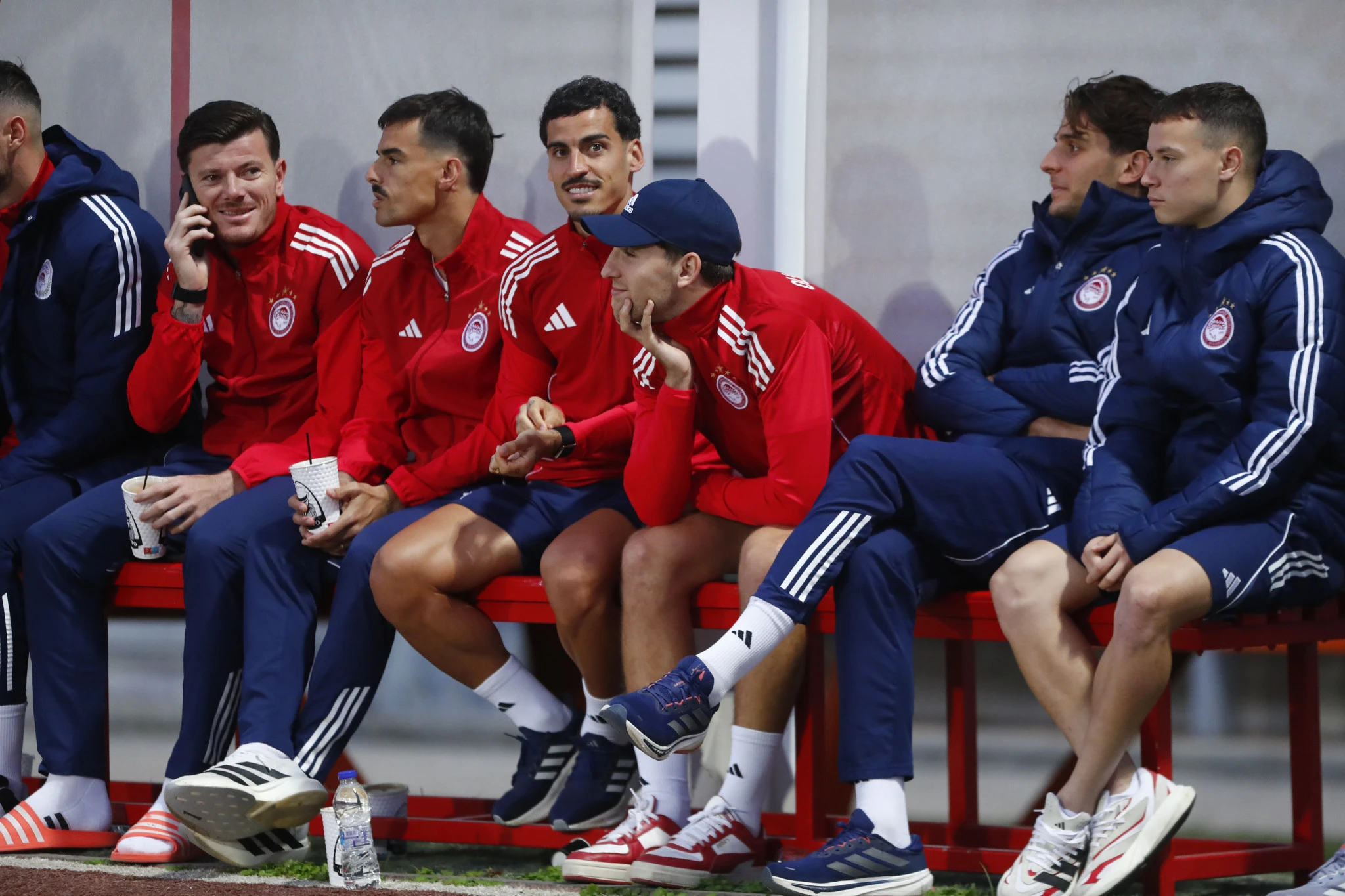 Οι παίκτες του Ολυμπιακού παρακολουθούν τις προσπάθειες της ομάδας Νέων / Πηγή: Eurokinissi