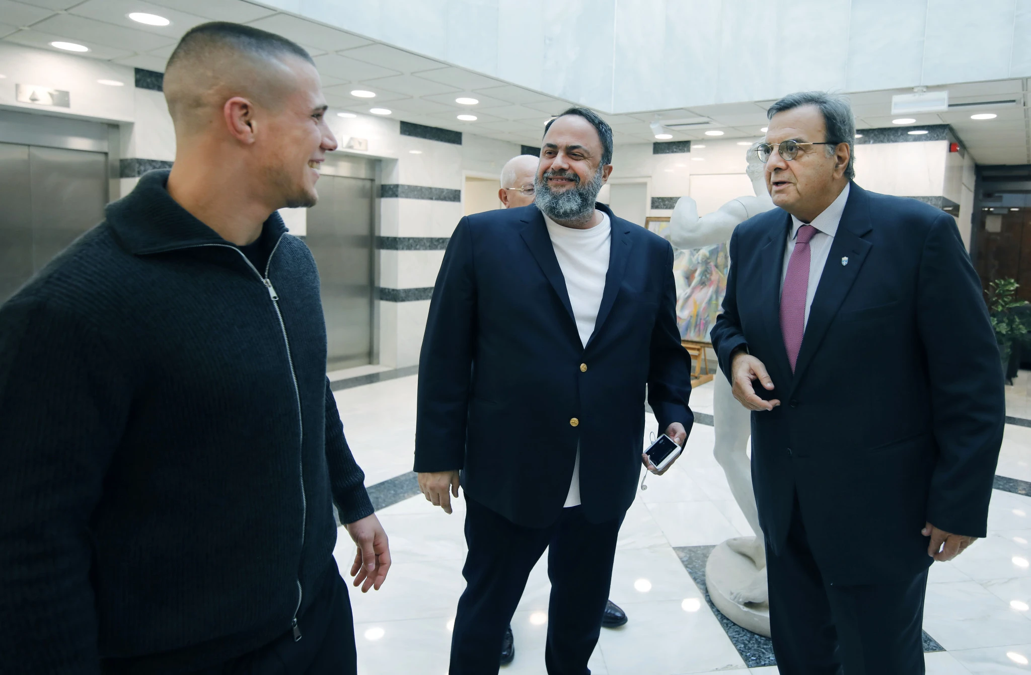 Ο Βαγγέλης Μαρινάκης συνομιλεί με τον Γιώργο Κουγιουμτσίδη και τον Ισίδωρο Κούβελο/Πηγή: Ελληνική Ολυμπιακή Επιτροπή