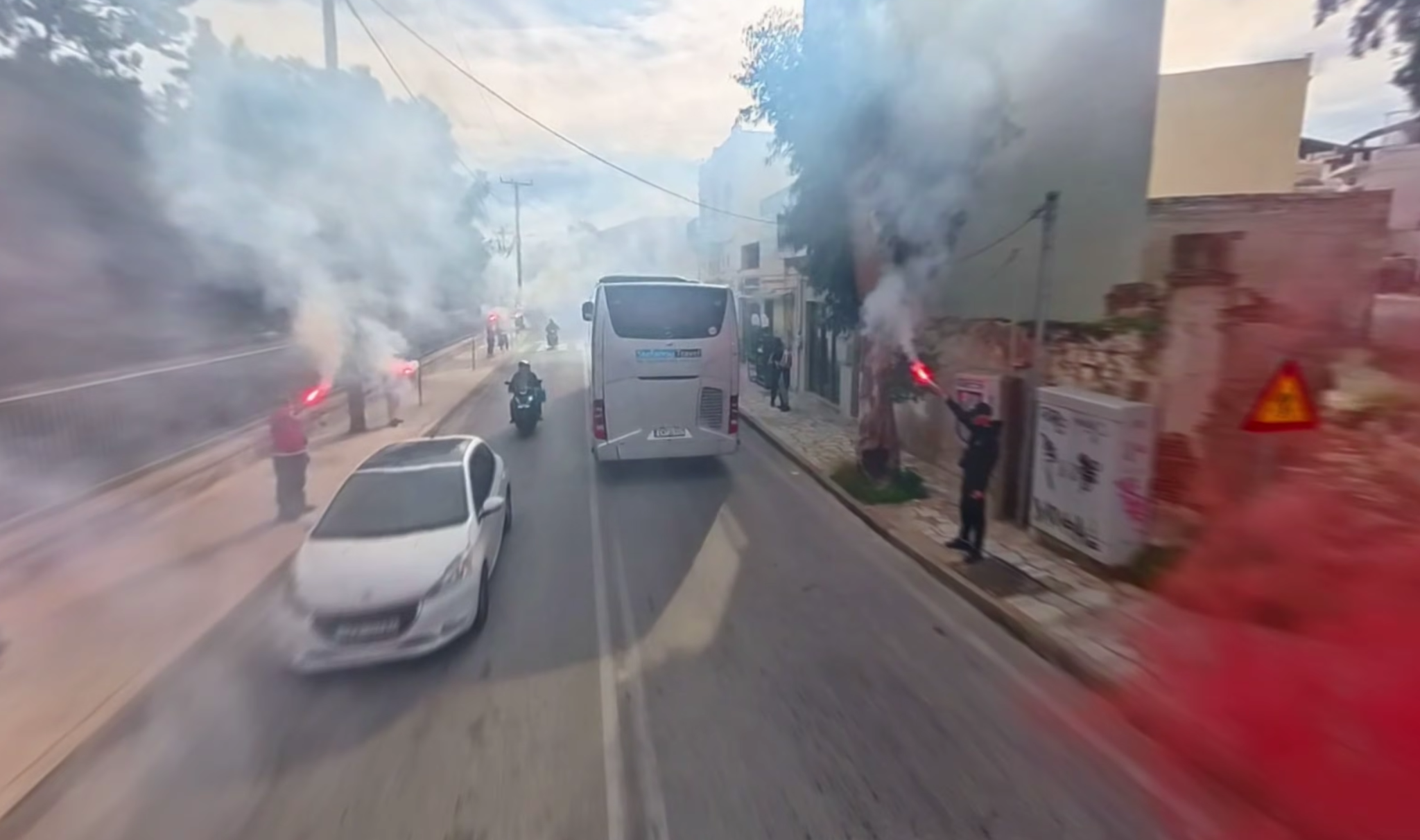 Η εντυπωσιακή ατμόσφαιρα των φίλων του Ολυμπιακού με πυρσούς και καπνογόνα στον δρόμο (video)